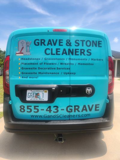 Back of a teal van advertising grave and stone cleaning services.