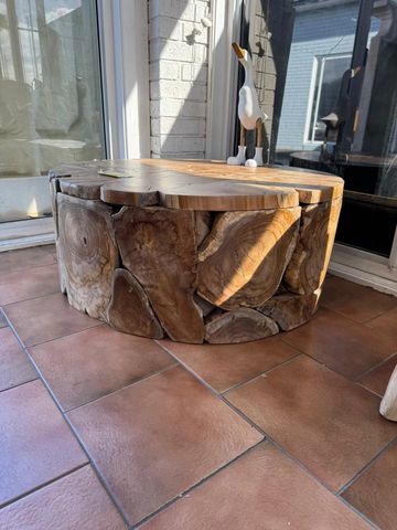 A round wooden coffee table made from natural wood slices.
