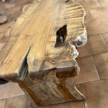 Rustic live-edge wooden table with natural grain patterns and irregular edges.