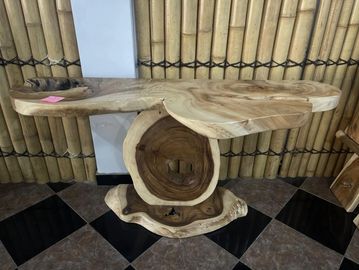 Artistic wooden table with natural wood grain and unique shape.