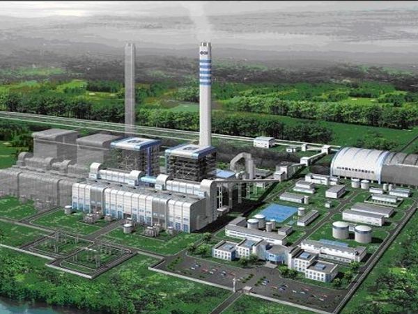 A large industrial power plant surrounded by greenery and water.