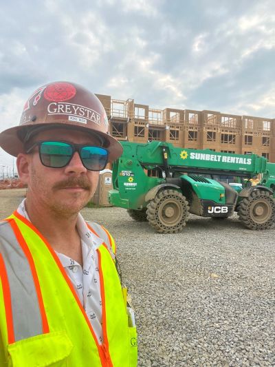 Construction worker in safety gear at a building site.