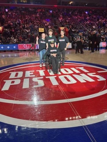Group photo on Detroit Pistons basketball court center.