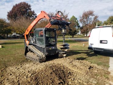 Using auger to dig holes for porch addition.