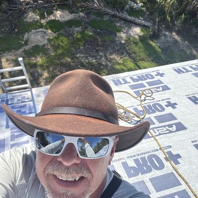 Man wearing a brown hat and white sunglasses.