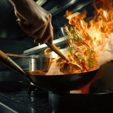 Picture of Chef cooking with wok and fire.