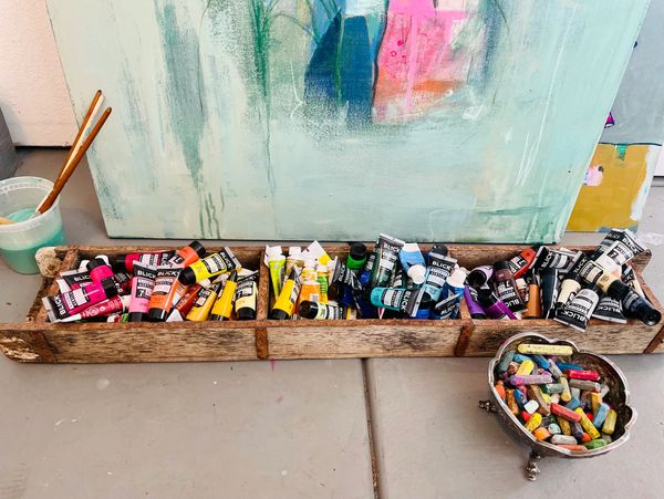 Art supplies including paint tubes and chalk pastels.