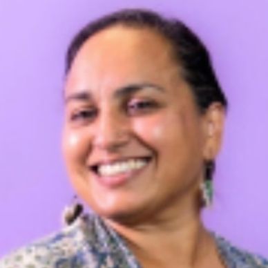 Smiling woman against a purple background.