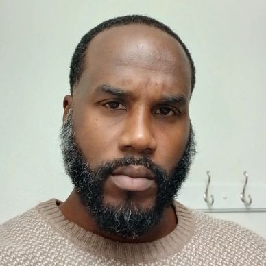 Portrait of a man with a beard and a serious expression.