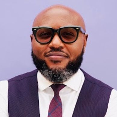 Man with glasses, beard, and suit vest