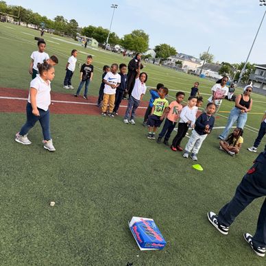 Children lined up outdoors on a field, preparing for a game or activity.