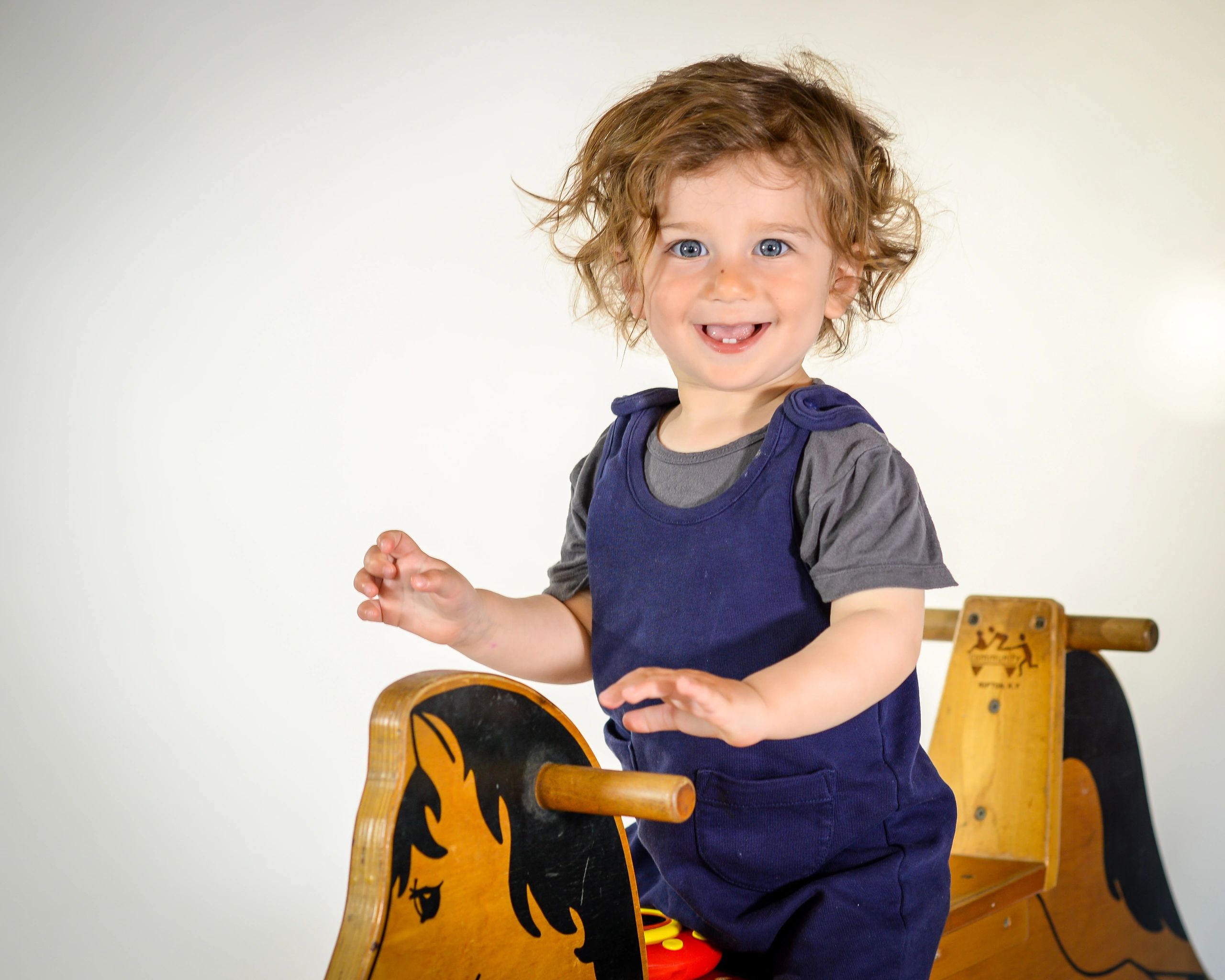 Photo of toddler on wooden rocking horse