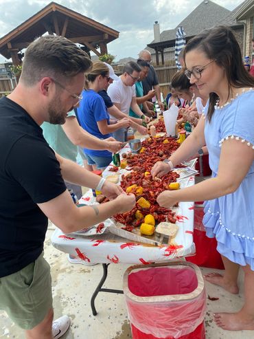 Group of people smiling and eating seafood.