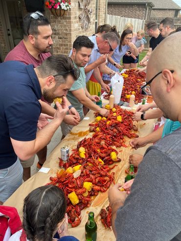 Group of people smiling and eating seafood.
