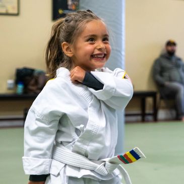 A young girl practicing self-defense in martial arts, specifically Tang Soo Do Karate. 