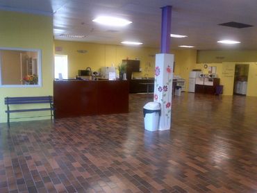 Spacious room with yellow walls, bench, and a decorated pillar.