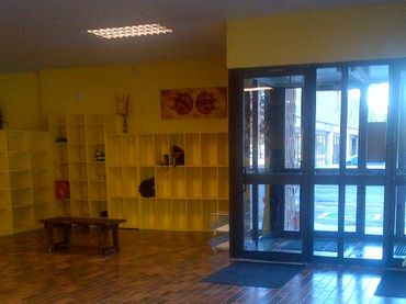 Bright room with yellow shelves, brick floor, and glass door.