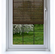 Shade on a window made of translucent fabric showing only some of what is outside the window.