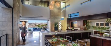 Woman in her kitchen using a wall touch screen to access her home automation system