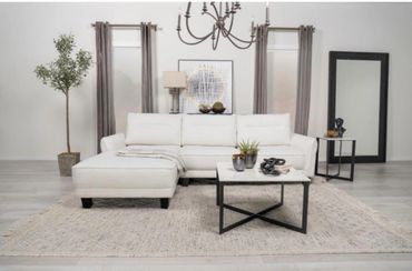Modern living room with white sectional sofa, coffee table, and minimalist decor.