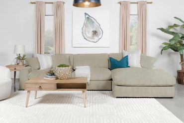 Modern living room with beige sectional sofa and wooden coffee table.