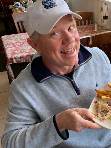 A happy customer holding up his salmon patty combination plate.