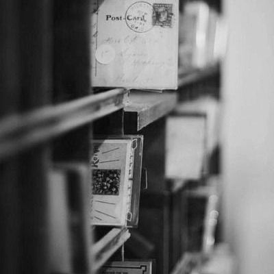 Black and white photo of postcards on shelves.