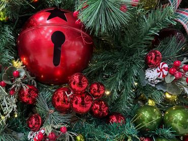 Festive Christmas wreath decorated with red and green ornaments and pine foliage.