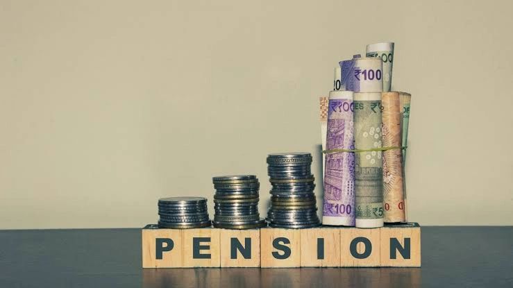 Stacked coins and rolled currency on blocks spelling PENSION.