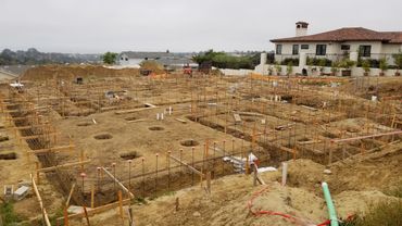 Construction site with foundation rebar and wooden framework preparation.