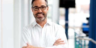 A man with glasses and beard wearing white shirt