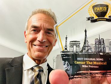 Mike Petrone holding his award from The Paris Film Festival.