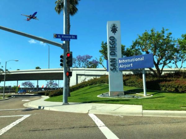 Entrance to San Diego International Airport with a plane overhead.