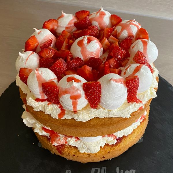 A two-layer sponge cake with cream, meringue, and strawberries.