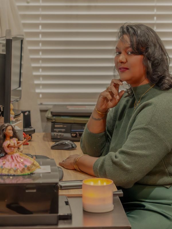Tamica Dizon working at desk with barbie doll