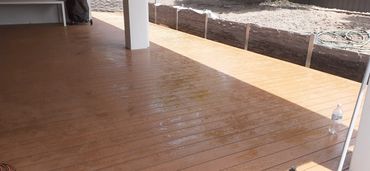 Wet wooden deck with sunlight and shadows.