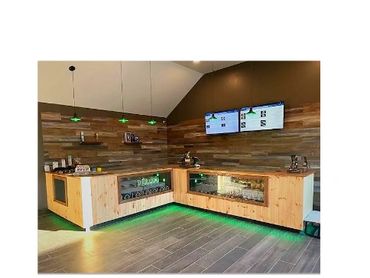 Modern wooden counter with green lighting and digital menu screens.