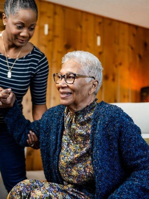 Young woman assisting elderly woman smiling.