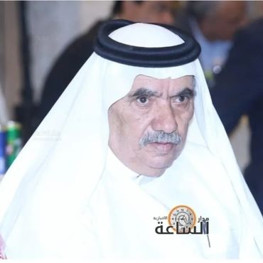 Elderly man in traditional white Middle Eastern attire with a serious expression.