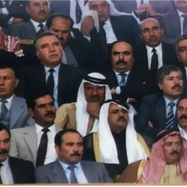 Group of Middle Eastern men in traditional and formal attire at a gathering.