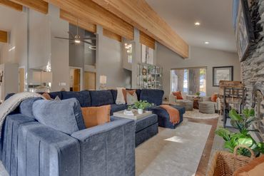 Spacious living room with navy sectional sofa and wood-beamed ceiling.