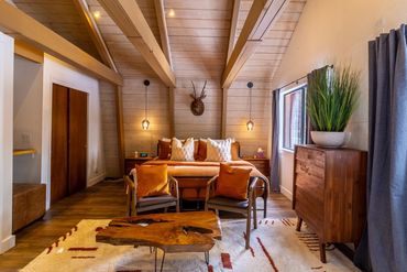 Cozy rustic bedroom with wood accents and warm lighting.