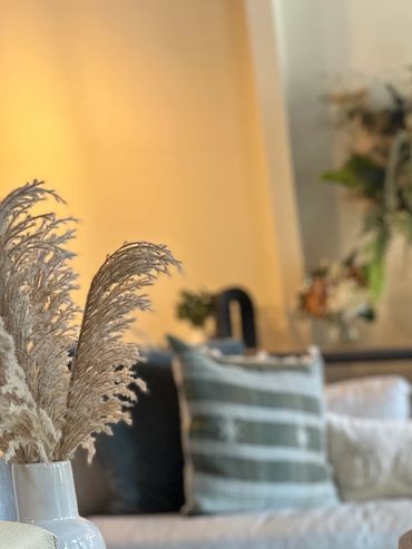 Cozy living room with wooden tables, decorative trays, and soft cushions.