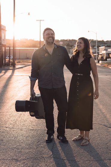 Male and female members of a Tucson acoustic cover band walk through the streets during golden hour