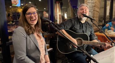 Live performance shot of a man and woman playing in an acoustic cover band in Tucson
