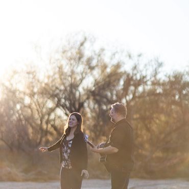 Members of an acoustic cover band walk together in a wash near Tucson, AZ at golden hour