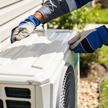Technician inspecting an outdoor air conditioning unit near a house.