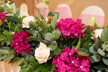 Elegant floral arrangement with vibrant pink and soft cream flowers on a table.