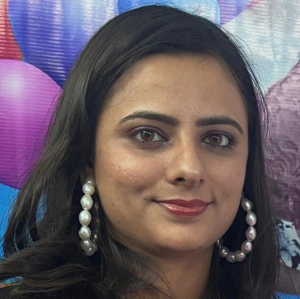 Close-up portrait of a woman with pearl hoop earrings and subtle makeup.