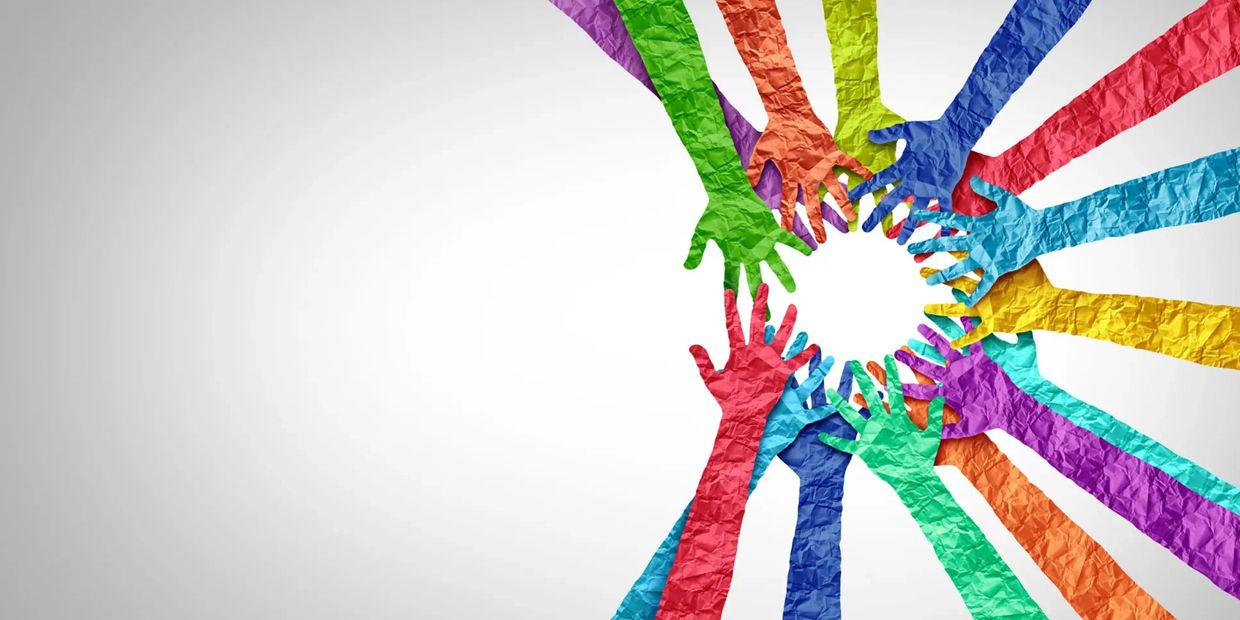 Colorful paper hands arranged in a circle symbolizing unity.